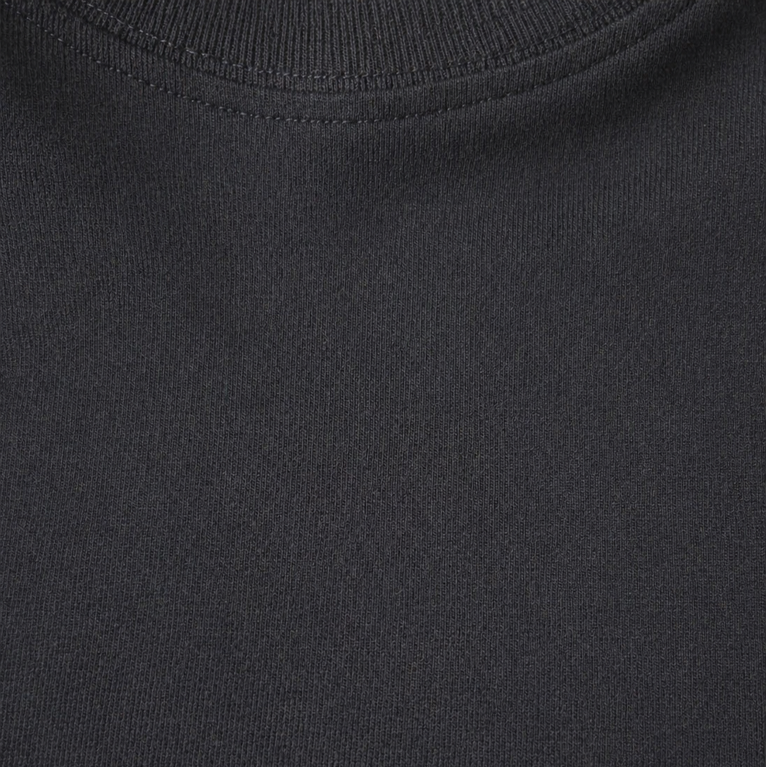 Close-up of a plain black t shirt with a visible brand logo.